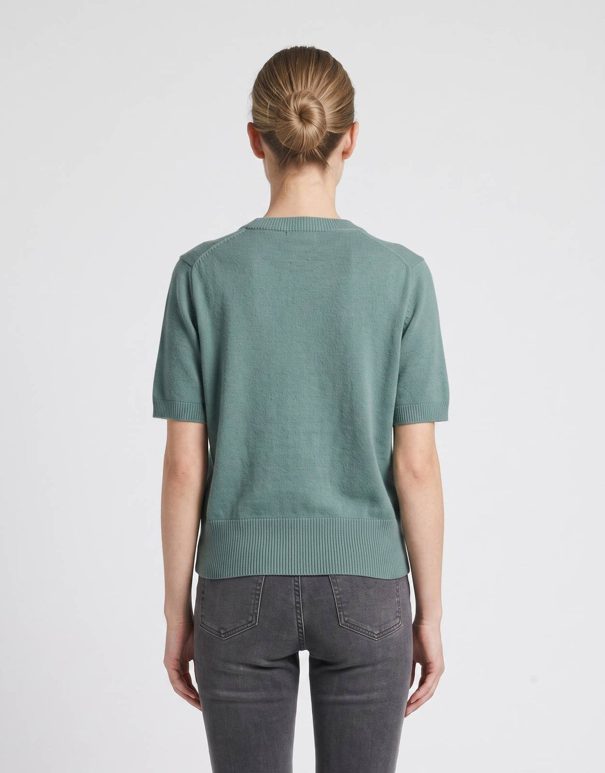 Calvin Klein Chunky Graphic Knit in green, short-sleeved, worn by a woman facing away.