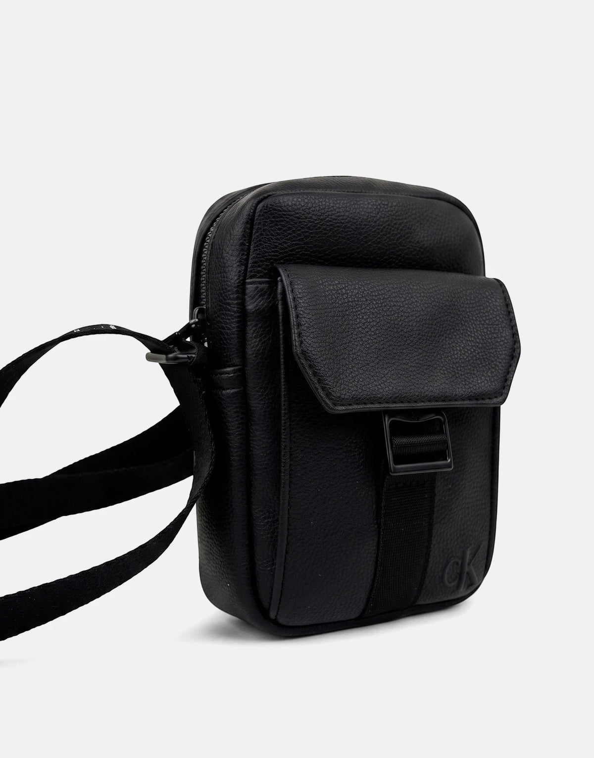 Black Calvin Klein webbing strap slim reporter bag, made of textured faux leather, featuring a front flap pocket and a top