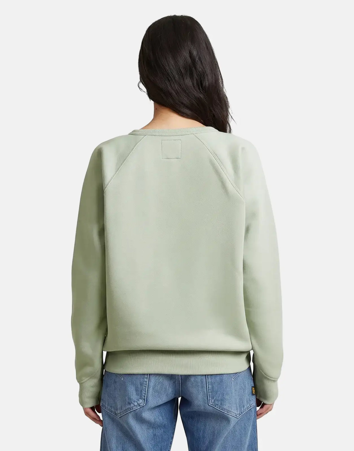 G-Star RAW Premium Core 2.0 pale green sweatshirt for women, shown from the back, paired with blue denim jeans.