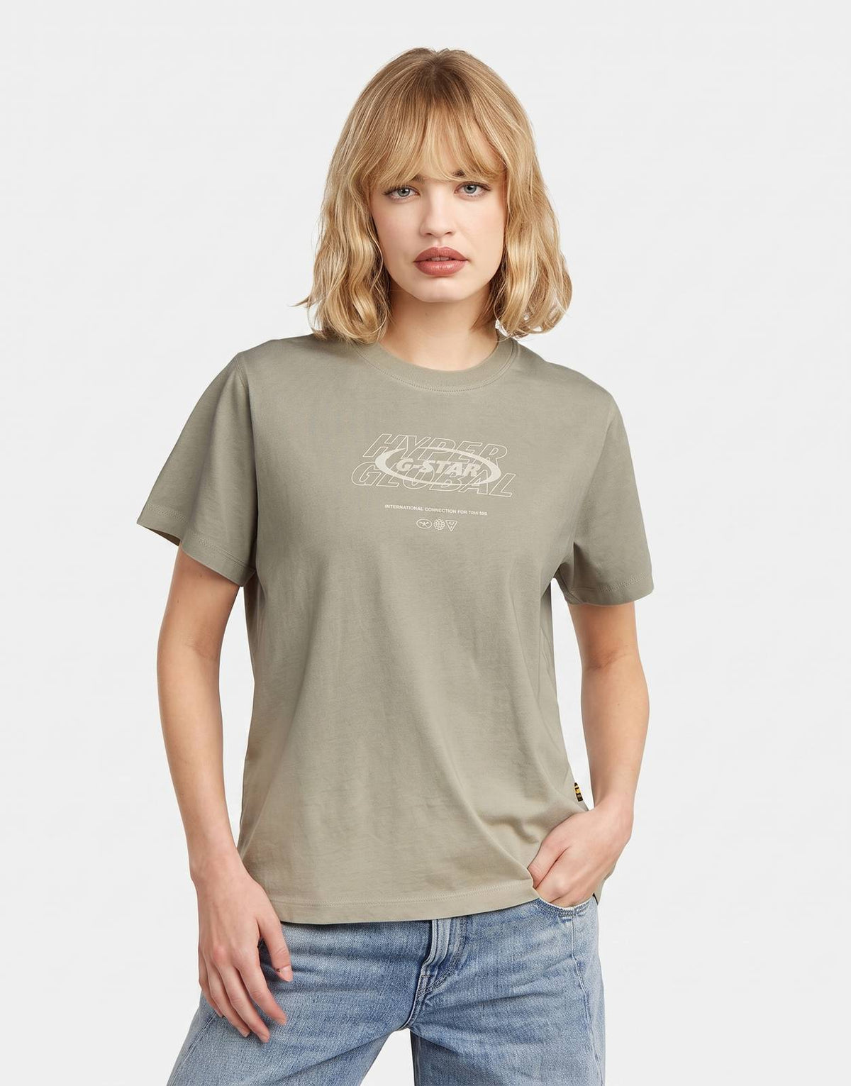 A woman models a G-Star RAW Sprayed Hyper Graphic Kit/lt Orphus Spray T-Shirt in light olive, front view.