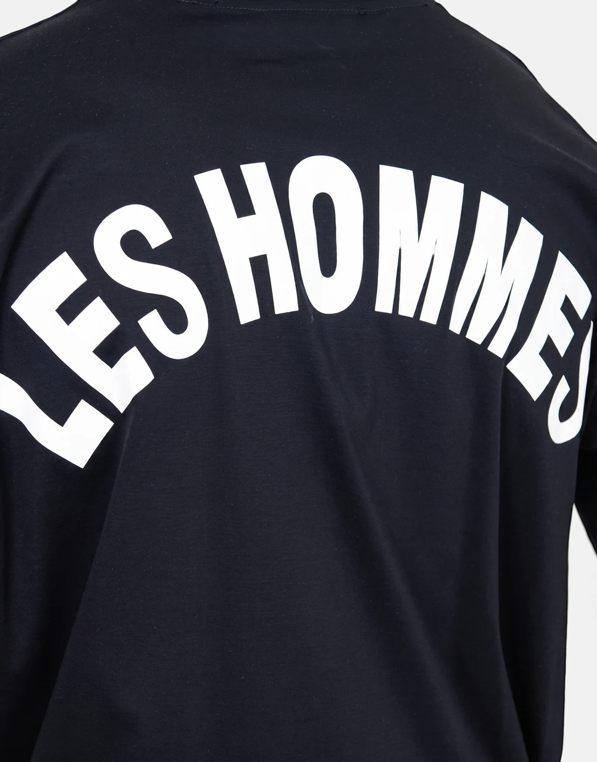 Les Hommes black t-shirt featuring a large white arched 'LES HOMMES' logo prominently displayed on the back, shown from the