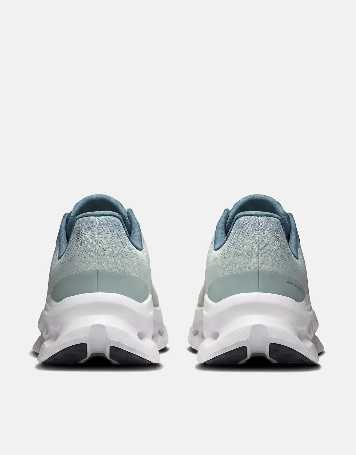 Back view of On Men's Cloudtilt Tide Mineral sneakers. The running shoes are light blue and mint green with white soles.