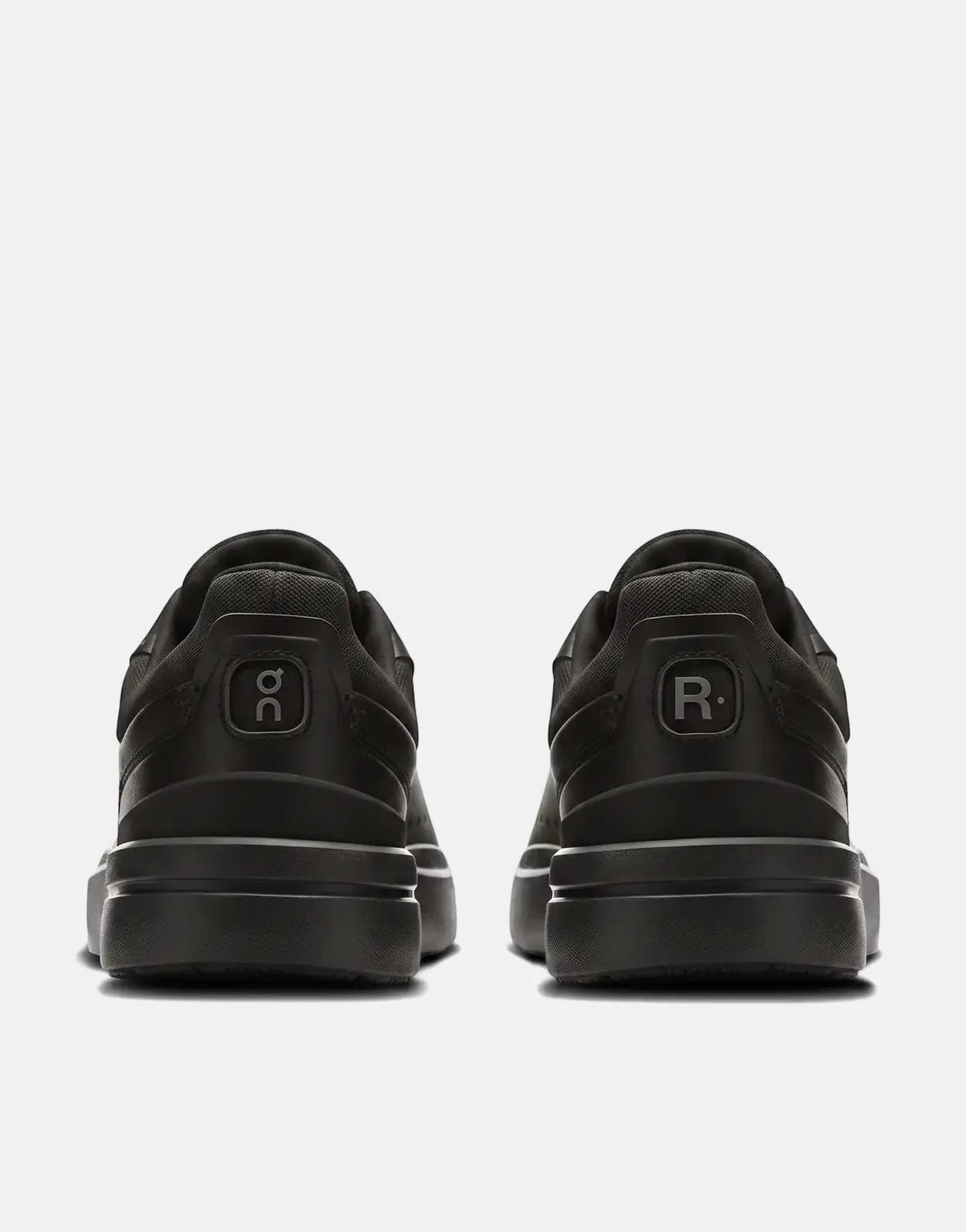 On Men's Roger Advantage black sneakers, featuring the 'o𝕔' and 'R.' logos on the heel, displayed from the back.