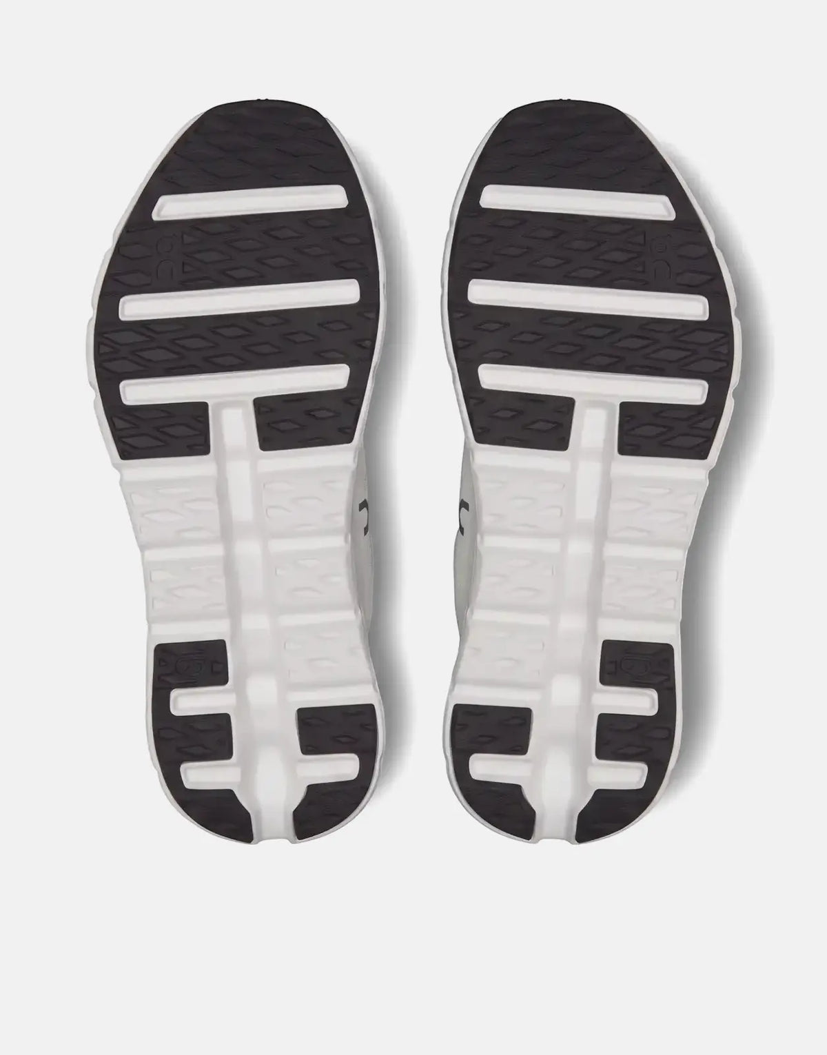 Bottom view of two On Unisex Cloudtilt Black Ivory running sneakers, showcasing the black and white textured soles.