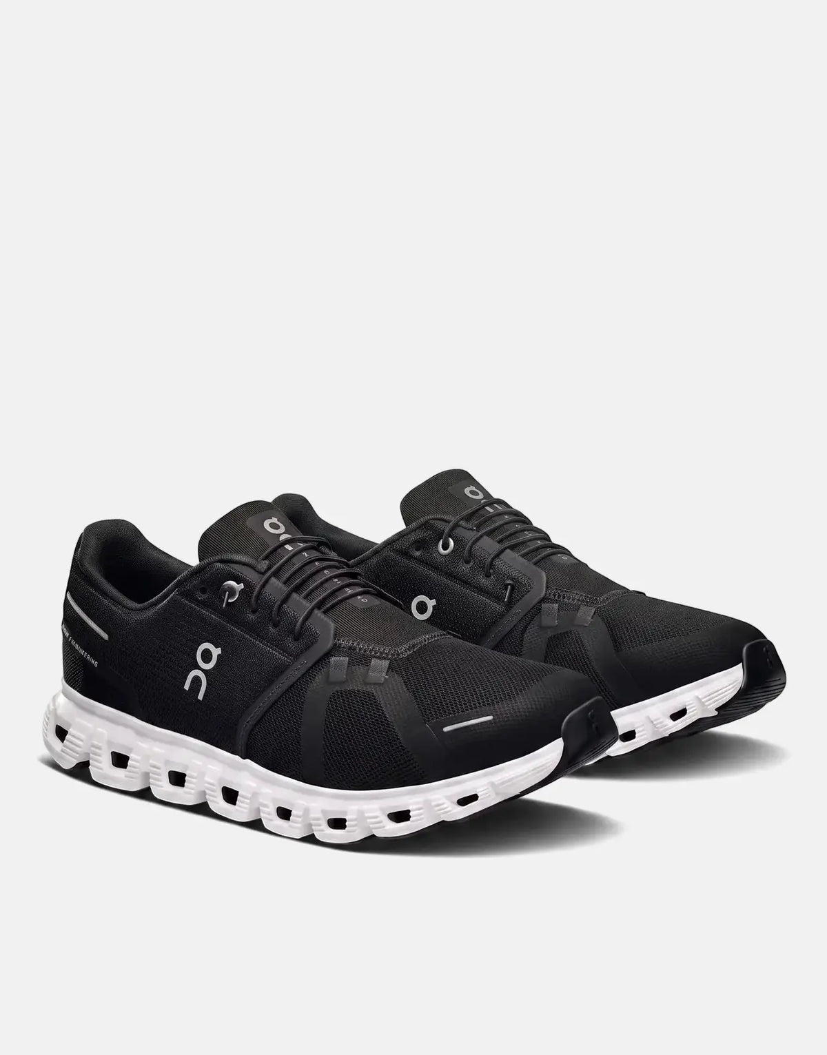 A pair of On Women's Cloud 6 Black White Sneakers, featuring a black mesh upper and a distinct white CloudTec sole, angled