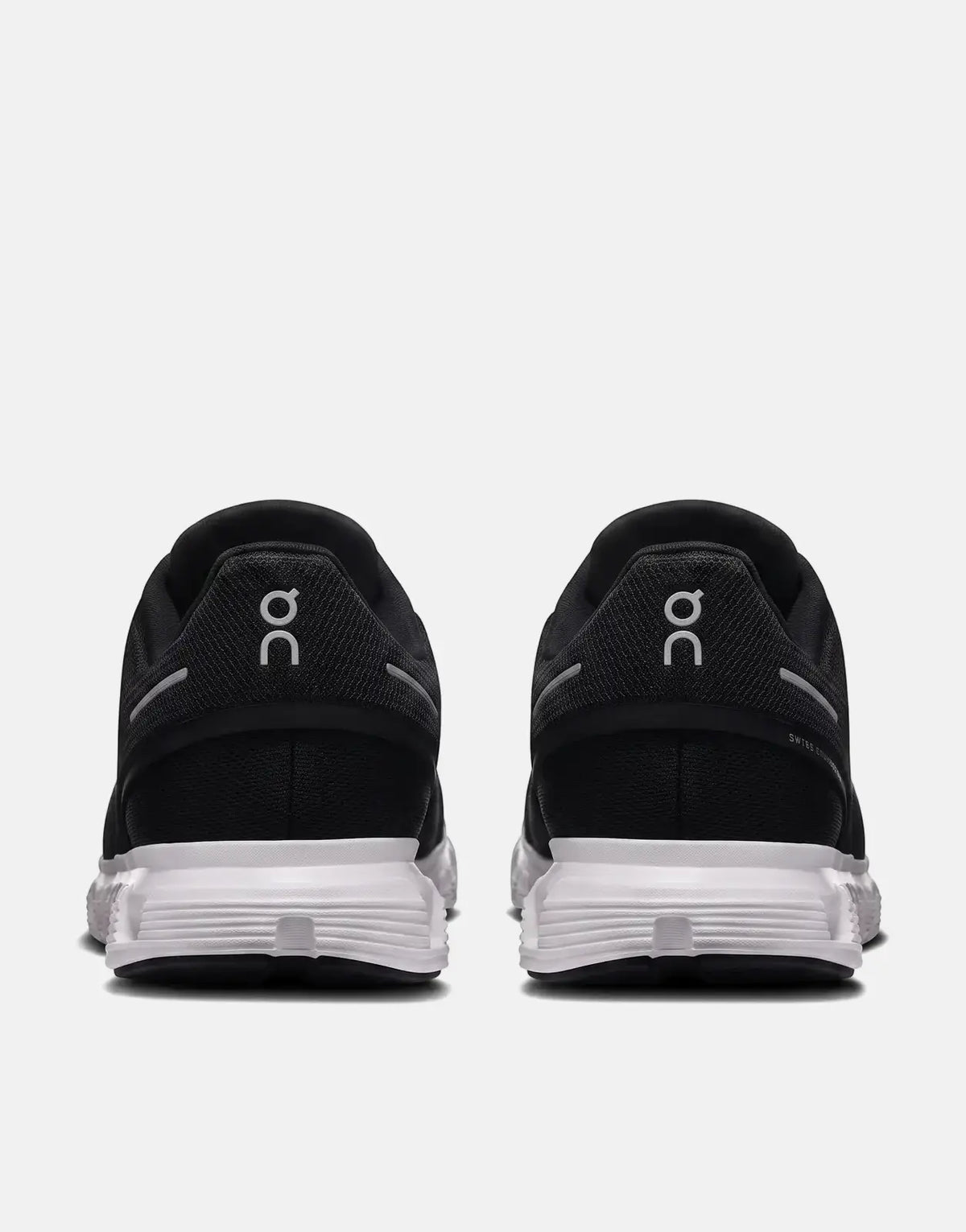 On Women's Cloud 6 sneakers in black and white, featuring a mesh upper and cloud-like sole, shown from the rear view.