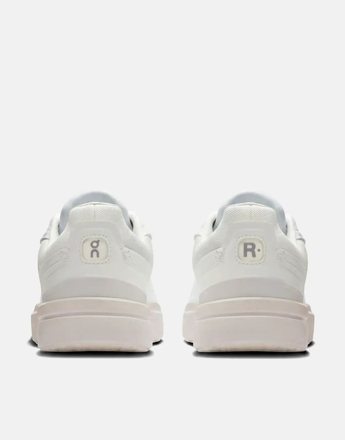 Back view of On Women's Roger Advantage sneakers in white, featuring the 'oc' and 'R.' logos on the heels.