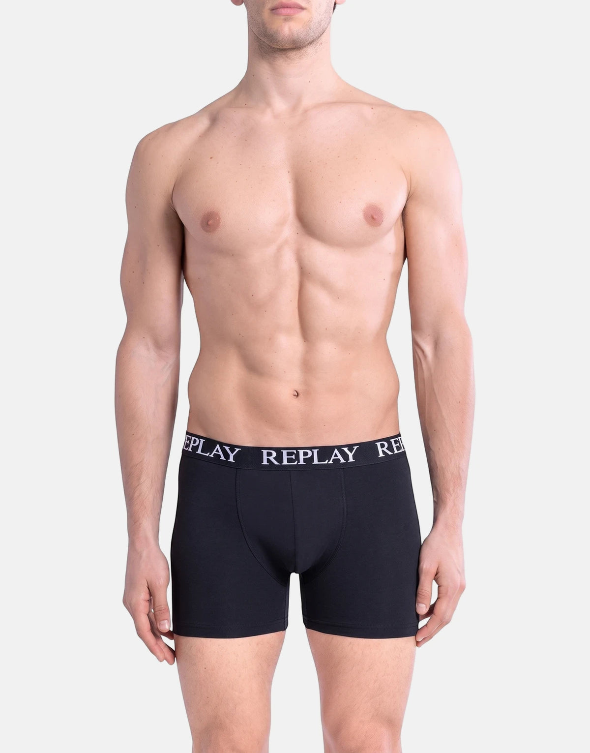 Replay men's black boxer briefs worn by a model, featuring a white branded waistband and a mid-thigh length.