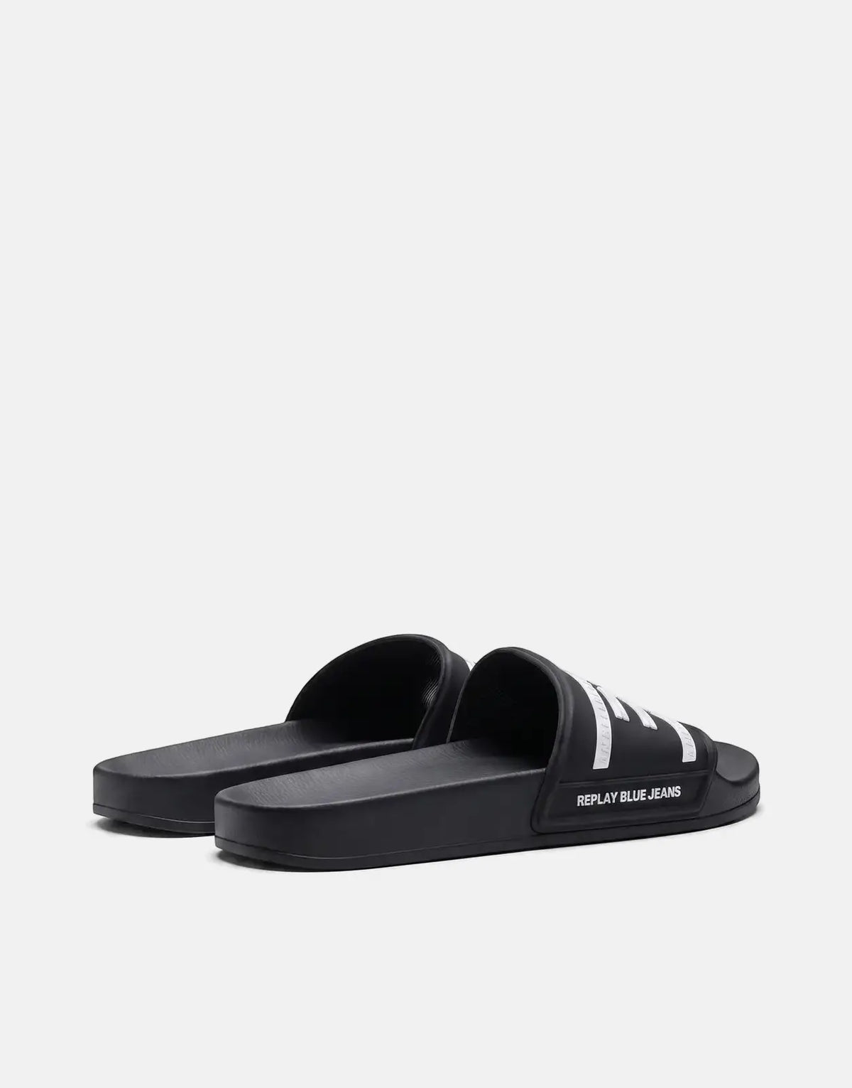 Replay Up Graven Black and White Slides shown from a low, slightly rear-side angle, featuring logo details on the strap.