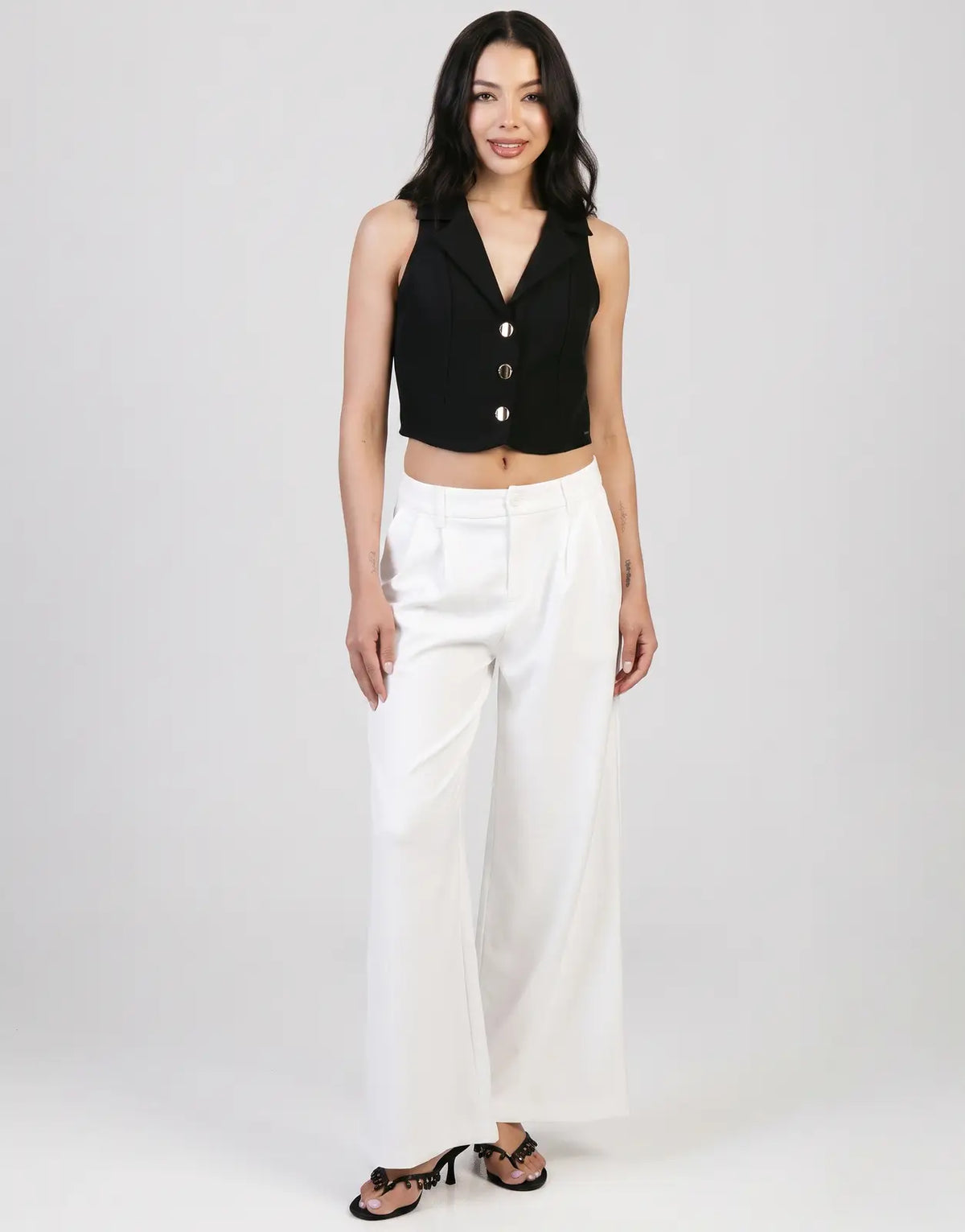 Sissy Boy Alice wide leg off-white trousers worn by a female model with a black sleeveless crop top and heels.