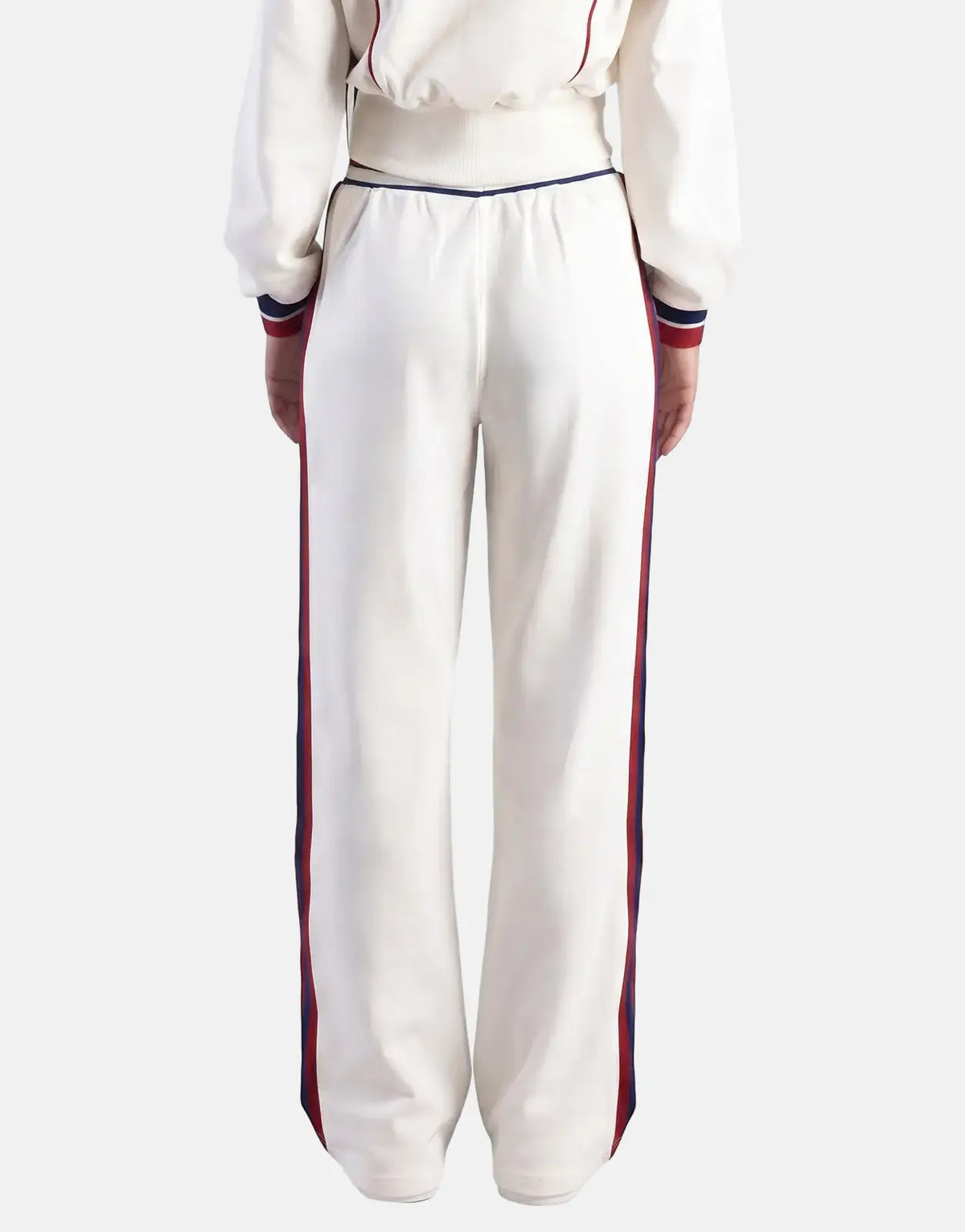 White Sissy Boy Off Your Game wide-leg sweatpants featuring red and blue side stripes, shown from the back perspective.