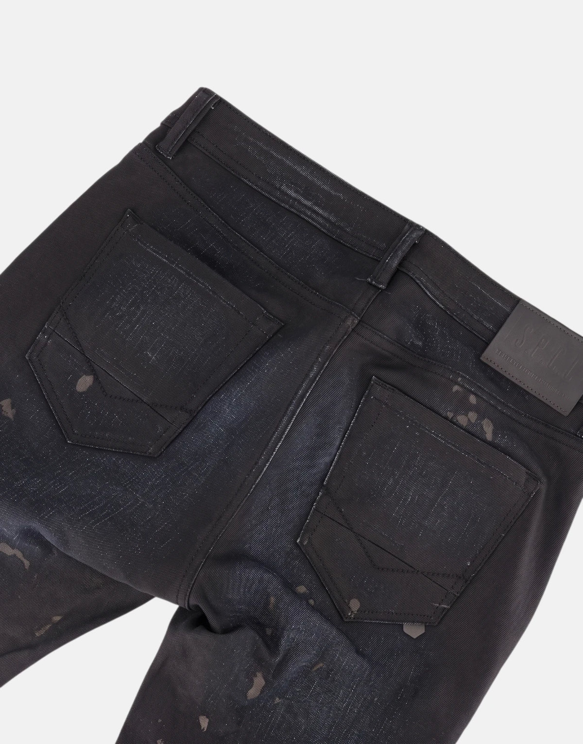 Black SPCC Eclipse jeans, photographed from the rear to highlight the back pockets, leather brand patch, and distressed