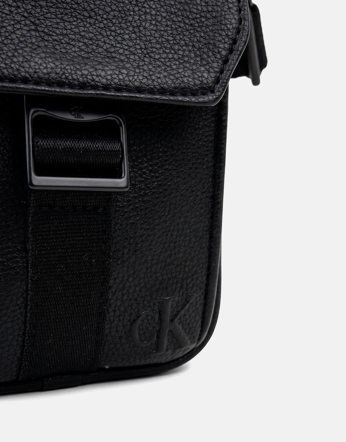 Calvin Klein Webbing Strap Slim Black Reporter Bag, front view, made of textured leather, with an embossed logo.