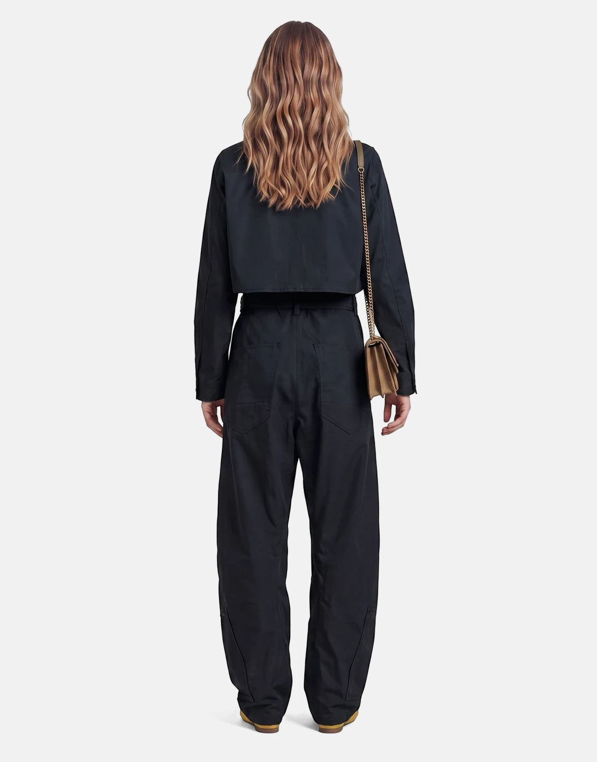 Rear view of a model wearing a black G-Star RAW Fightsuit Salute Jumpsuit, featuring a cropped jacket and wide-leg pants.