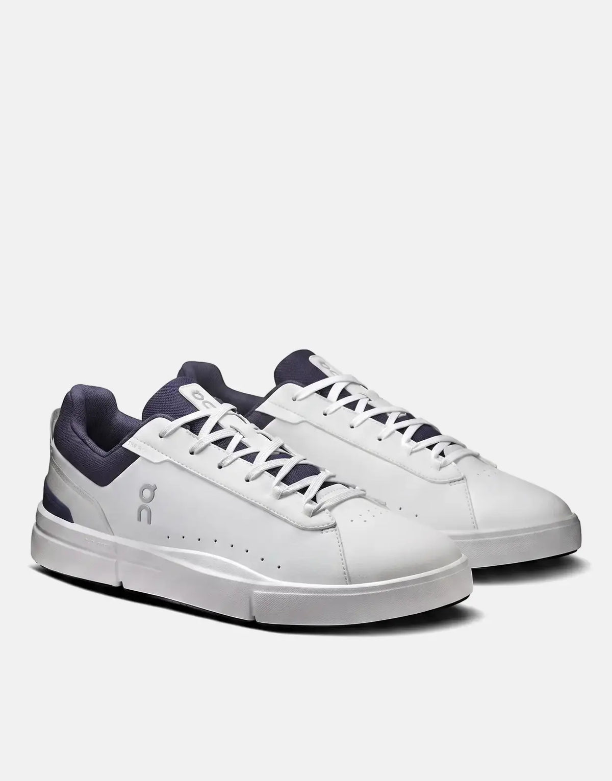 A pair of On Men's The Roger Advantage sneakers in white and midnight blue, with white laces and silver accents, from a side