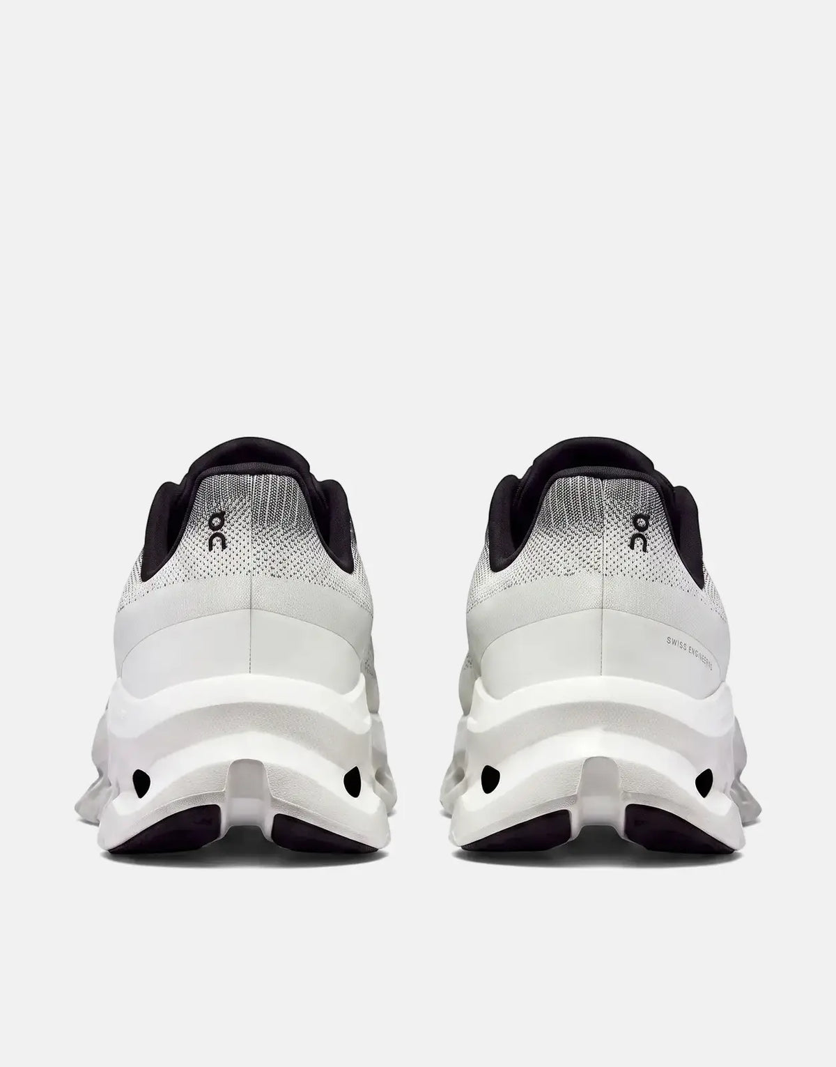 On Unisex Cloudtilt running sneakers in black and ivory, shown from the back, highlighting the textured upper and sculpted
