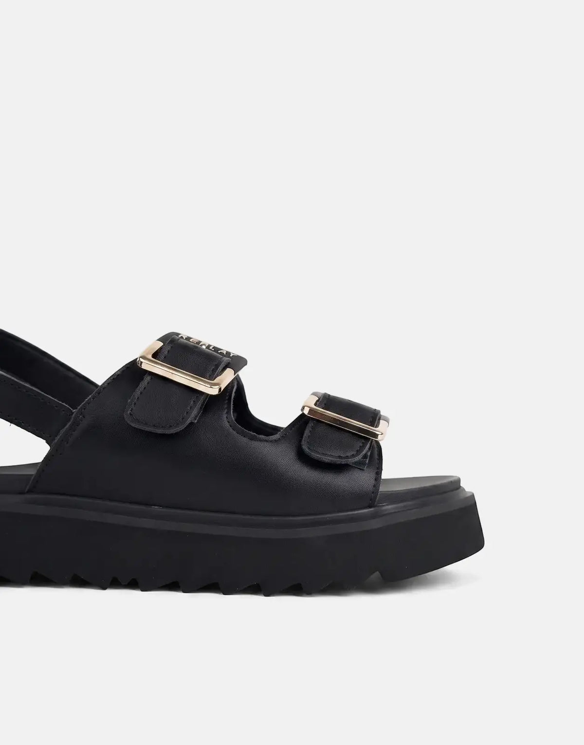 Close-up of a black leather Replay platform sandal with two gold-tone buckles and a chunky ridged sole.