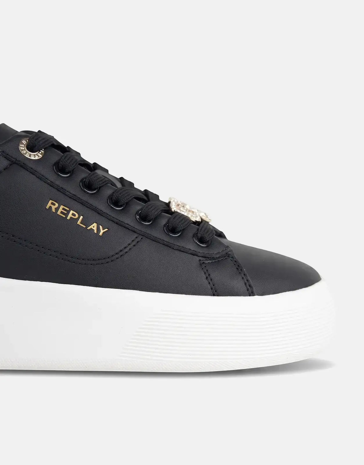 Close-up of a black Replay Notting W Image sneaker with a white platform sole, black laces, gold logo, and a jewel charm.